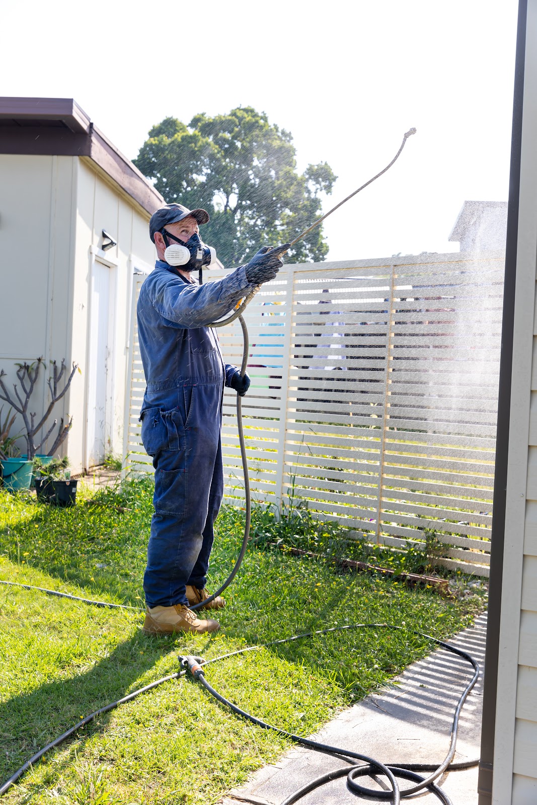 A technician treats a backyard fence